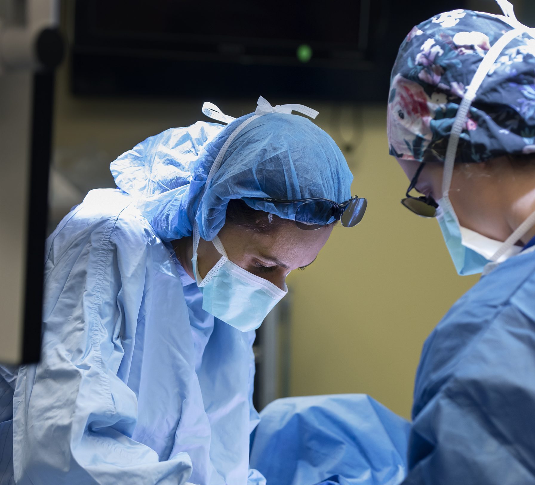 2 doctors operating on a patient